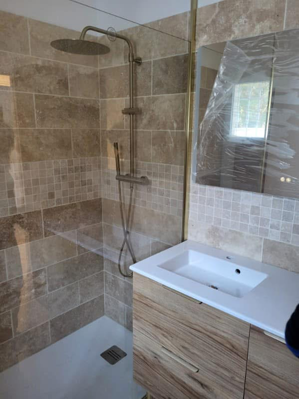 Salle de bain rénovée après travaux de plomberie MCP SARL, installation de meuble vasque, robinetterie moderne et finitions soignées.